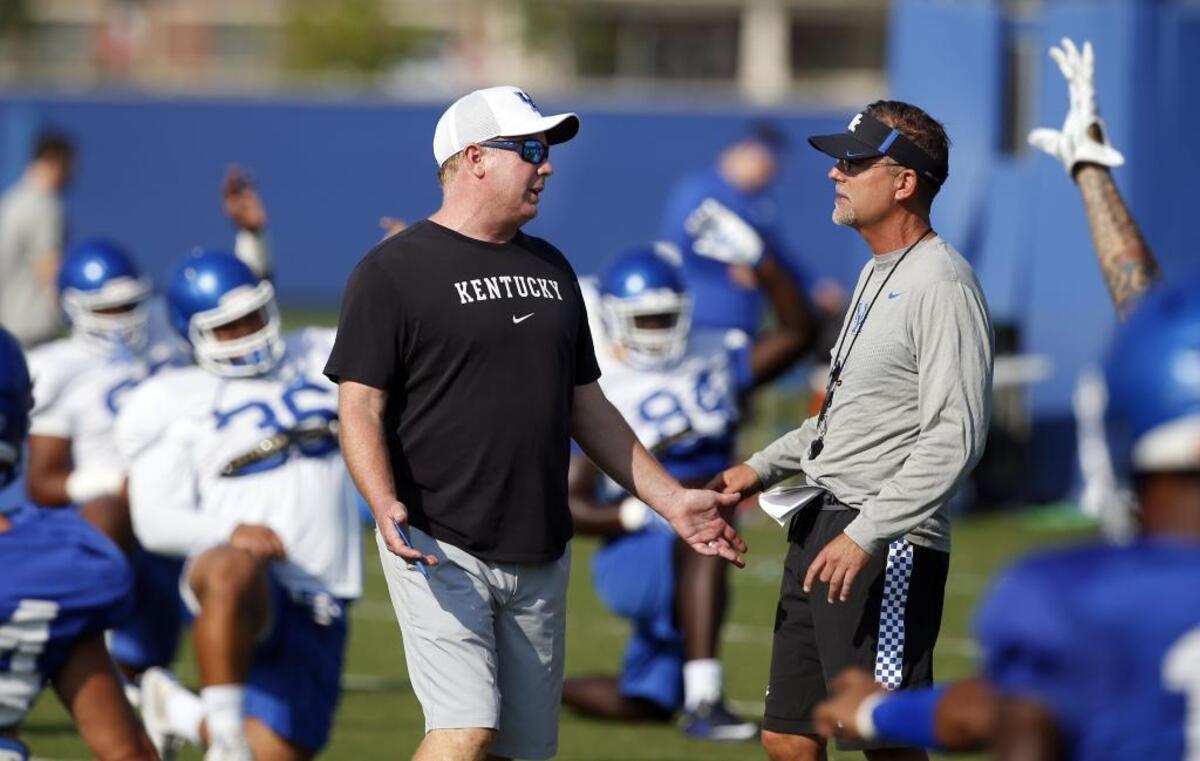 Head coach Mark Stoops, left, and offensive coordinator Eddie Gran changed up their practice routines in the spring and probably will in the fall to help simulate games while the quarterback competition plays out.