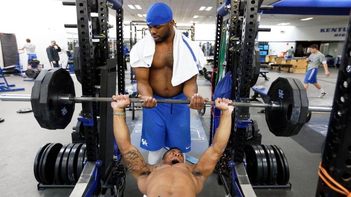 Transfer De'Niro Laster helps fellow linebacker Kobie Walker on the bench as part of the University of Kentucky football team took part in a weightlifting session in the E. J. Nutter Training Facility on campus in Lexington, Ky., Friday, February 26, 2016.