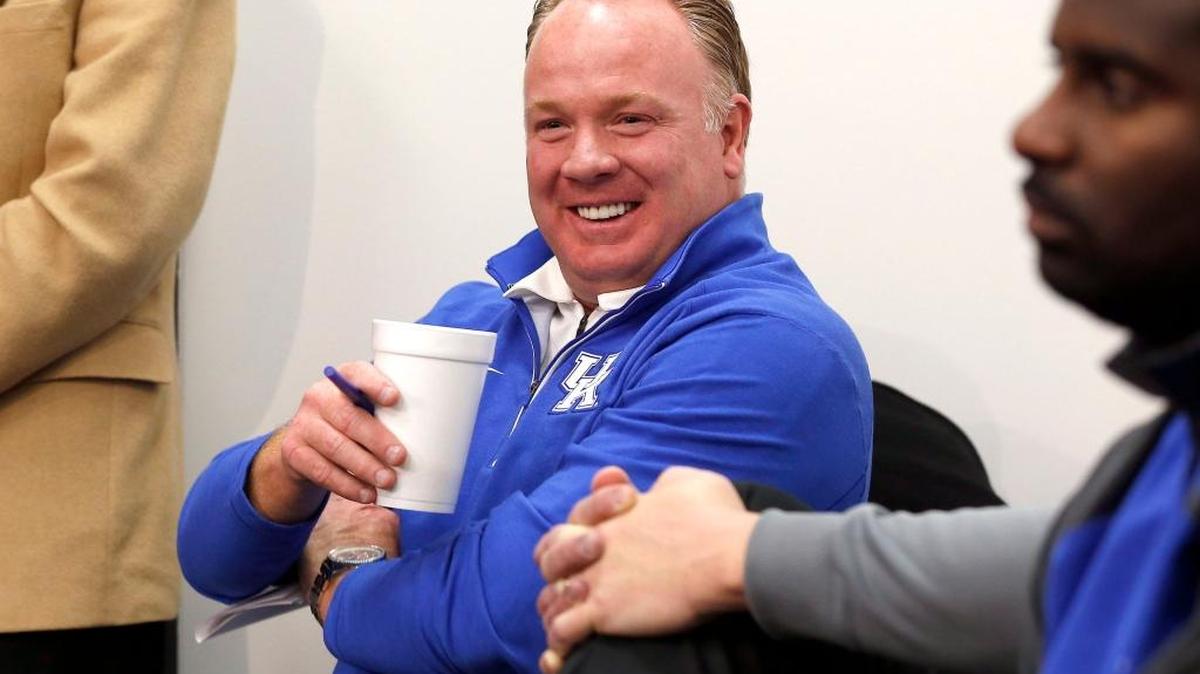 UK Coach Mark Stoops laughed during a news conference Monday at Commonwealth Stadium. Stoops introduced new coaches Darin Henshaw and Eddie Gran.