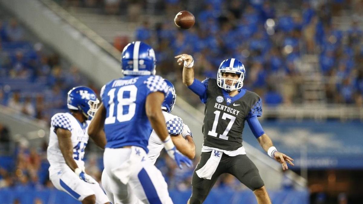 Kentucky quarterback Walker Wood (17) passed the ball over white team defenders during the Blue-White Spring Game Friday at Kroger Field.
