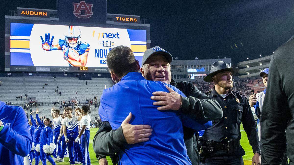 Kentucky Wildcats head coach Mark Stoops gets a congratulatory hug after UK defeated Auburn 10-3 Saturday.