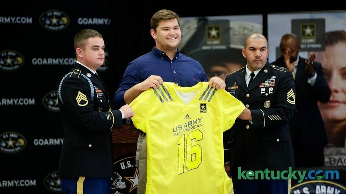 Woodford County High School football player Drake Jackson receives his U.S. Army All-American Bowl jersey from Staff Sergeant Cody Tribble , left, and Sergeant First Class Jesus Davalos.