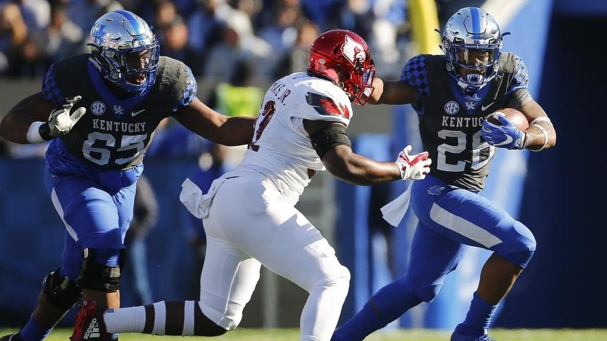 Kentucky running back Benny Snell (26) tried to outrun Louisville linebacker Stacy Thomas during their game at Kroger Field in Lexington on Saturday.