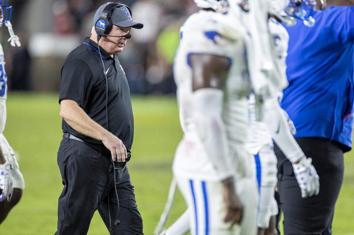 Kentucky head coach Mark Stoops walks to a huddle during a timeout in Saturday’s game against South Carolina at Williams-Brice Stadium in Columbia, S.C.