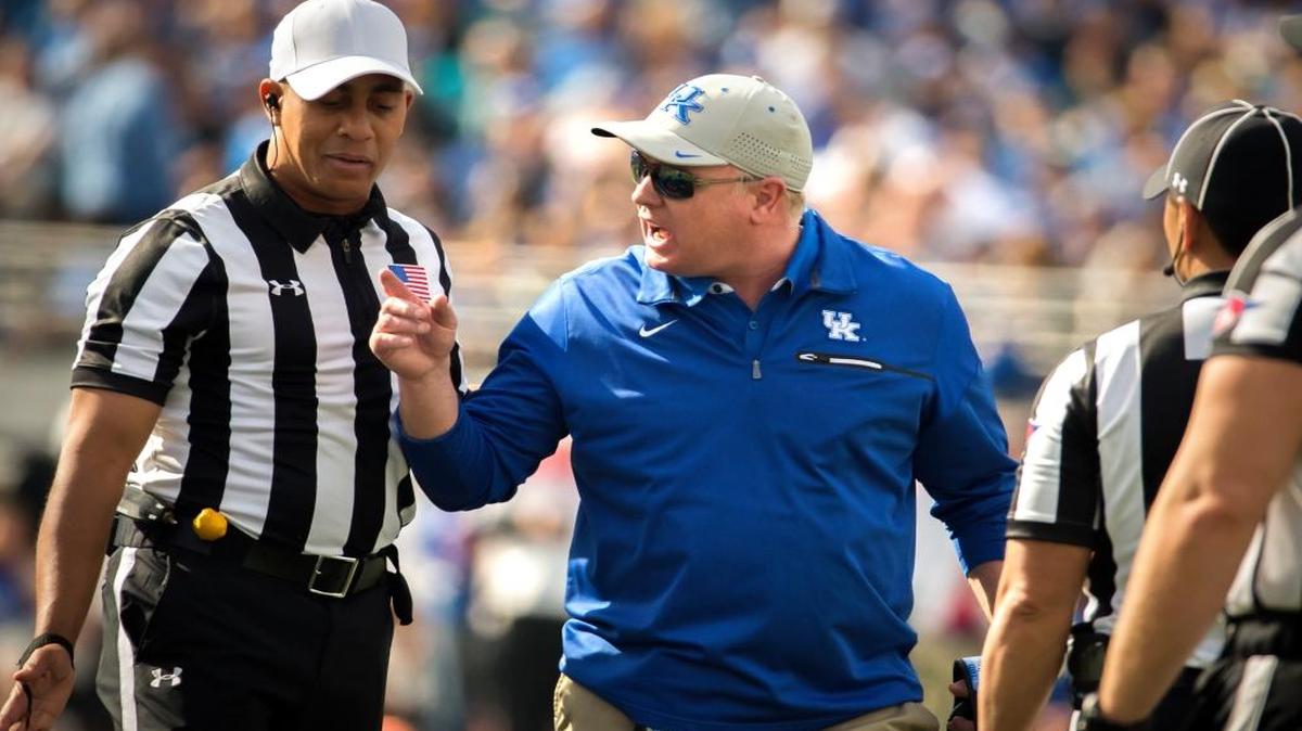 Kentucky head coach Mark Stoops, center, argues with Referee Reggie Smith, left, during the first half of the TaxSlayer Bowl NCAA college football game against Georgia Tech, Saturday, Dec. 31, 2016, in Jacksonville, Fla.
