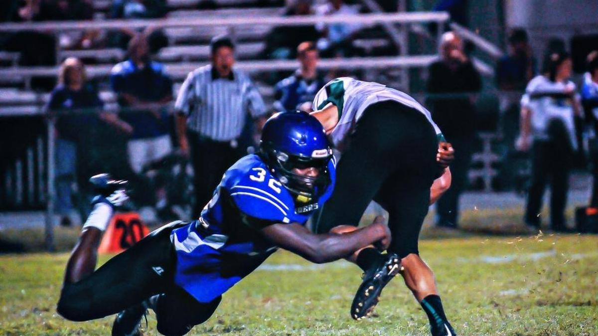 Eli Brown tackled Meade County’s Will King during a game at Warren East in 2014.