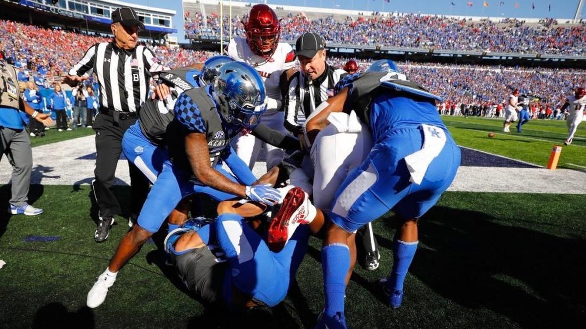 Kentucky and Louisville football players fight during the first quarter of Saturday’s game.