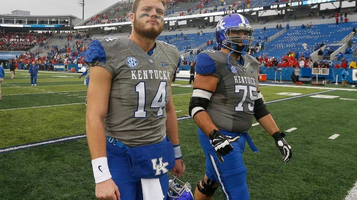 Kentucky Wildcats quarterback Patrick Towles (14) and Kentucky Wildcats guard Zach West (75) walked off the field after the University of Kentucky lost to the University of Louisville at Commonwealth Stadium in Lexington, Ky., Saturday, November 28, 2015. This is fourth quarter action. Louisville won 38-24.