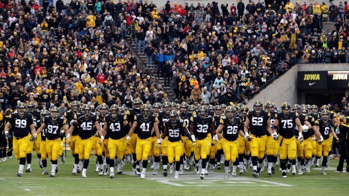 Iowa players run onto the field before an NCAA college football game against Nebraska, Friday, Nov. 25, 2016, in Iowa City, Iowa.