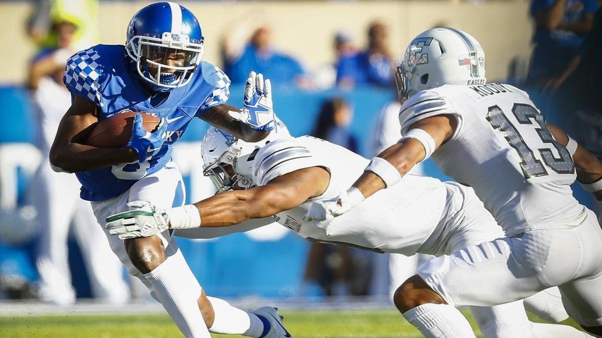Kentucky wide receiver Garrett Johnson (9) ran the ball before being stopped by Eastern Michigan linebacker Ike Spearman (9) and defensive back Justin Moody (13).