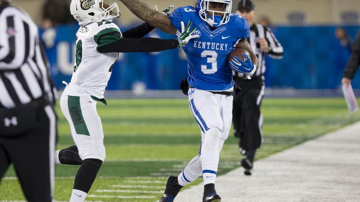 Kentucky running back Jojo Kemp (3) ran for 40 yards before being forced out of bounds by Charlotte defensive back Devin Pearson in the third quarter. Kemp rushed for a career-high 165 yards and three touchdowns.