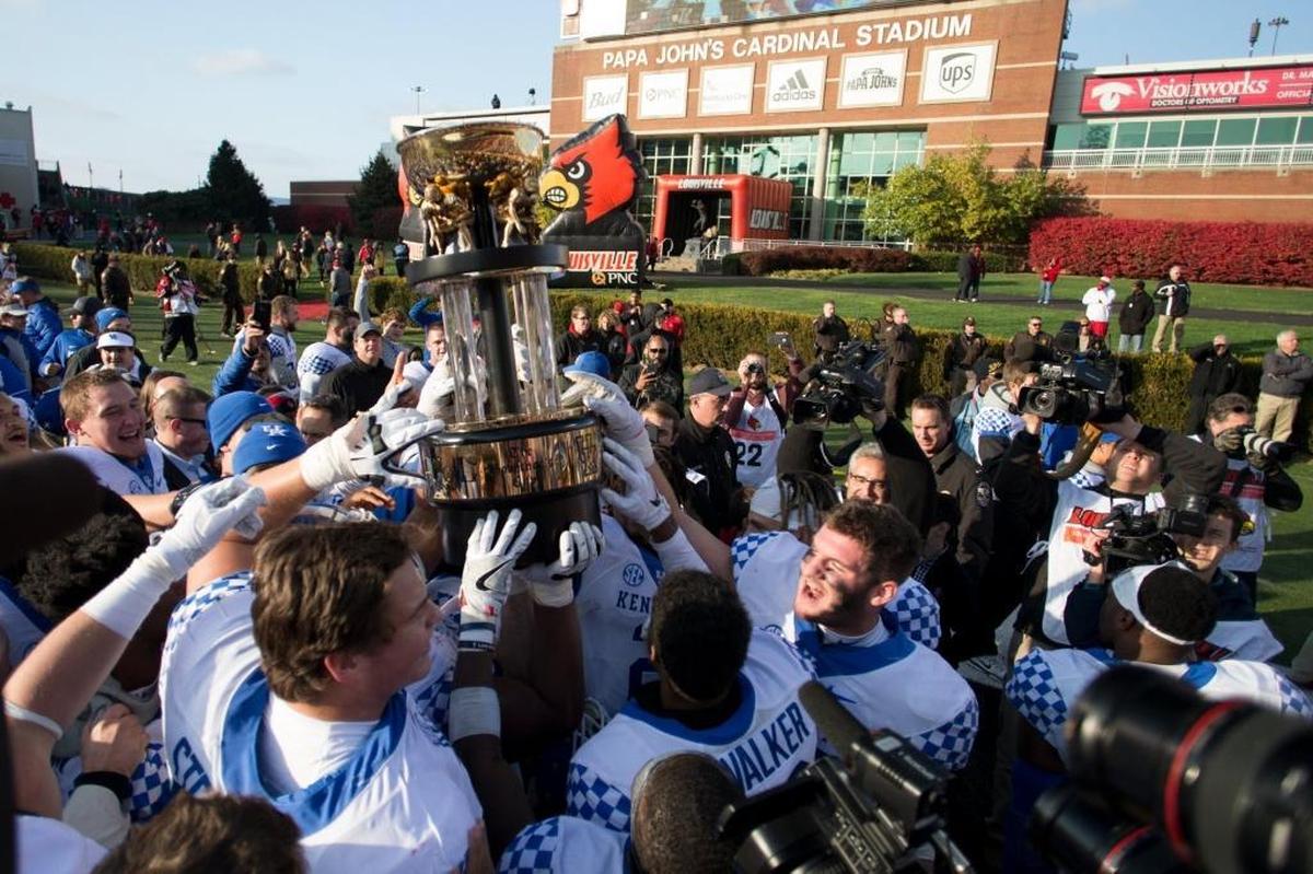 Kentucky’s players hoisted the Governor’s Cup after they defeated Louisville 41-38 on Nov. 26, 2016, at Papa John’s Cardinal Stadium.