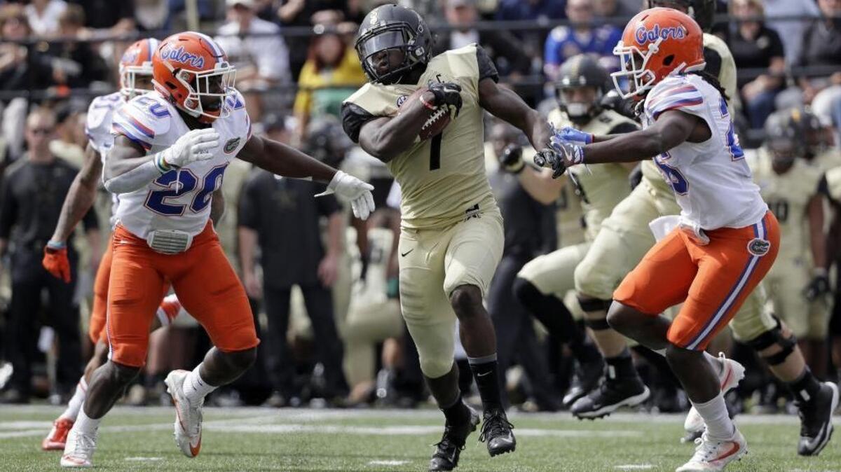 Vanderbilt running back Ralph Webb (7) is caught between Florida defenders Marcus Maye (20) and Marcell Harris (26) during the second half of an NCAA college football game Saturday, Oct. 1, 2016, in Nashville, Tenn. Florida won 13-6. (AP Photo/Mark Humphrey)