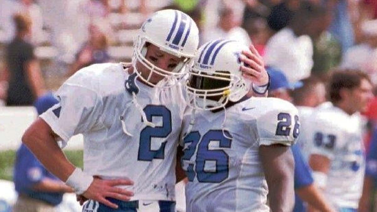 Kentucky quarterback Tim Couch, left, consoled safety Tremayne Martin after UK lost 35-27 to Mississippi State in Starkville on Sept. 6, 1997. The Wildcats have not lost the second game on their schedule since.