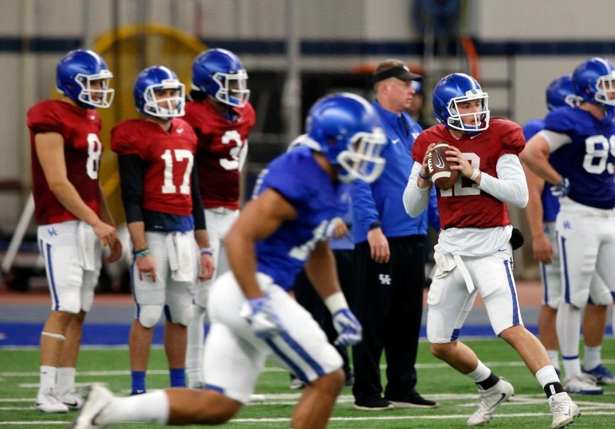 Gunnar Hoak (12) dropped back to throw a pass during one of UK’s spring practices. Left to right were quarterbacks Danny Clark (8), Walker Wood (17) and Terry Wilson (3) and quarterbacks coach Darin Hinshaw. Kentucky’s coaches discussed their plan for picking their next signal caller during luncheons this week.