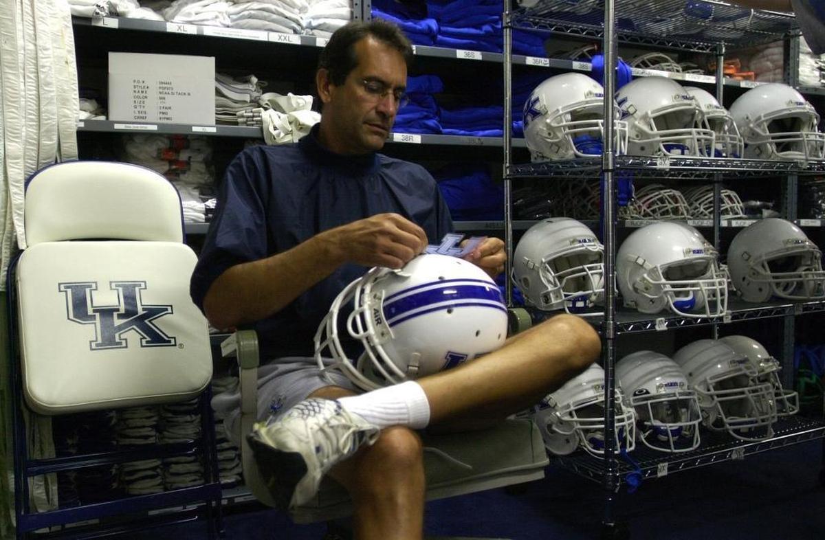 Tom Kalinowski put decals on helmets in the UK locker room while preparing for a game in 2002.