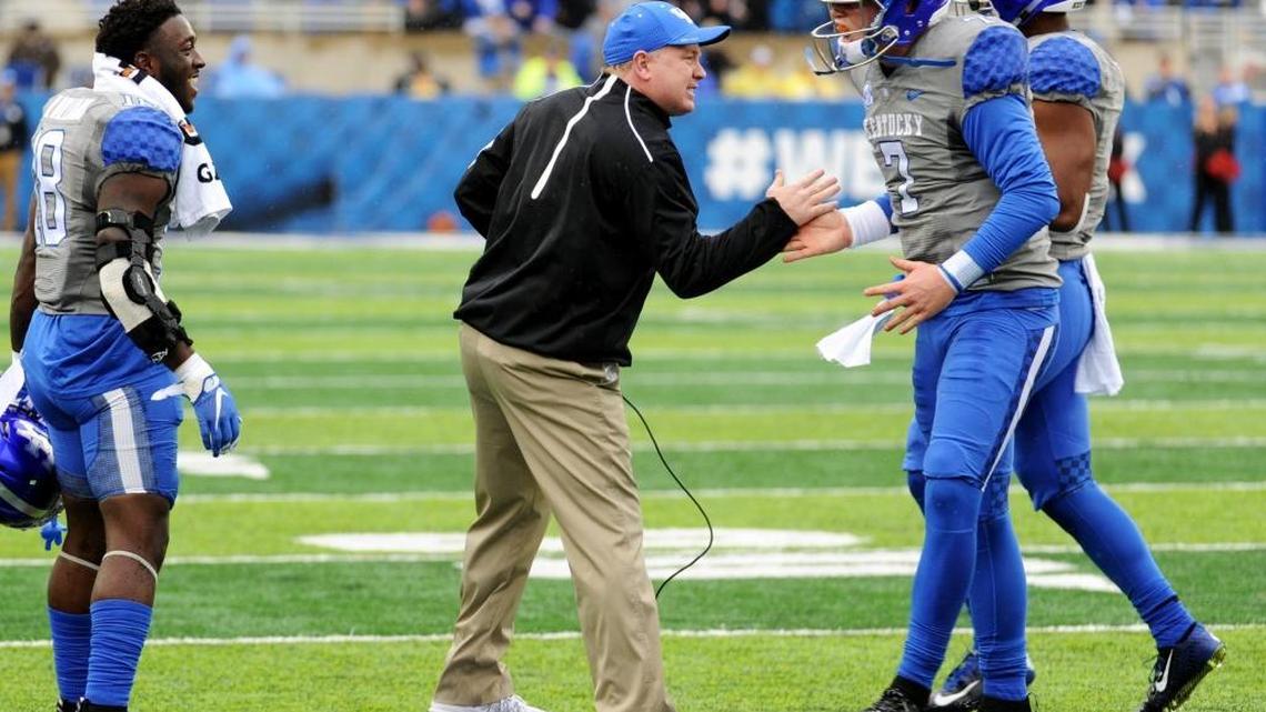 UK Coach Mark Stoops congratulated Drew Barker after the quarterback scored on a one-yard run against Louisville on Saturday, Nov. 28, 2015.