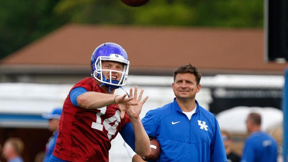 UK quarterback Patrick Towles throws as offensive coordinator Shannon Dawson looks on at the Tim Couch Practice Fields during UK Football Fan Day in Lexington, Ky., Saturday, August 8, 2015.