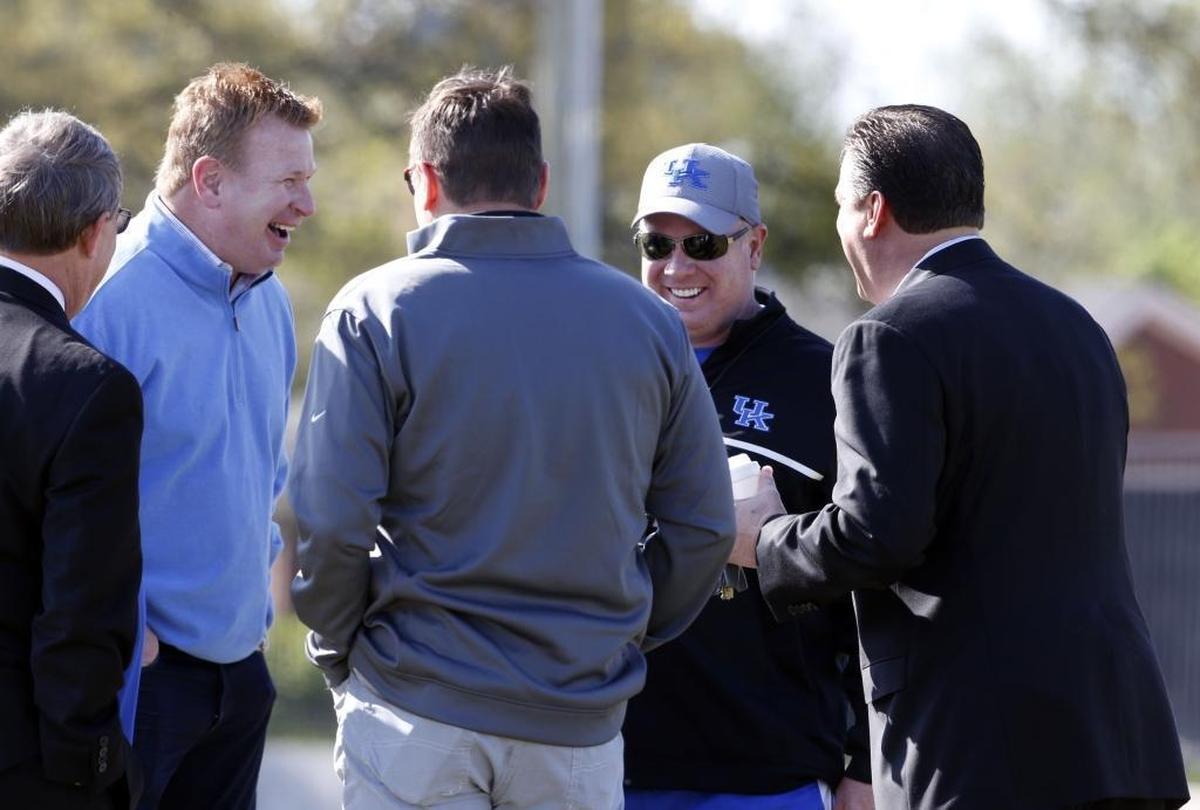 Mike Stoops, Bob Stoops and Mark Stoops talked with UK basketball coach John Calipari during a UK football practice in 2014.
