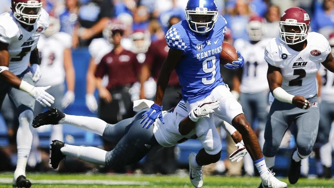 Kentucky wide receiver Garrett Johnson (9) carried the ball past Eastern Kentucky defensive back Ben Bascom (18) on Saturday.