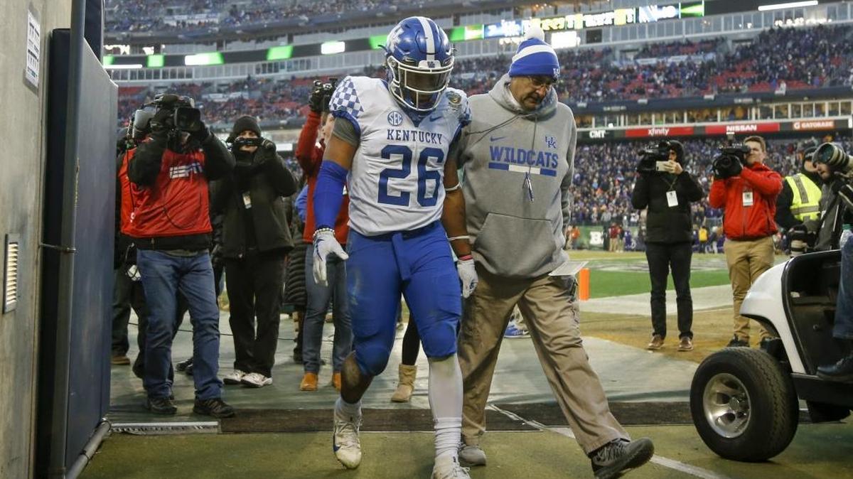 Kentucky running back Benny Snell Jr. (26) is escorted off the field after being ejected for a unsportsmanlike penalty against the Northwestern Wildcats during the first half of the Music City Bowl at the Nissan Stadium in Nashville, TN., on Friday, December 29, 2017.