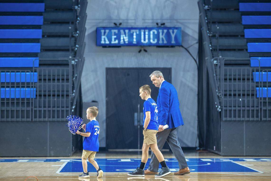 Mitch Barnhart, with his grandsons Gunner and Cooper, walks to a press conference on the court of Historic Memorial Coliseum in Lexington to announce his retirement as the University of Kentucky’s athletic director.  