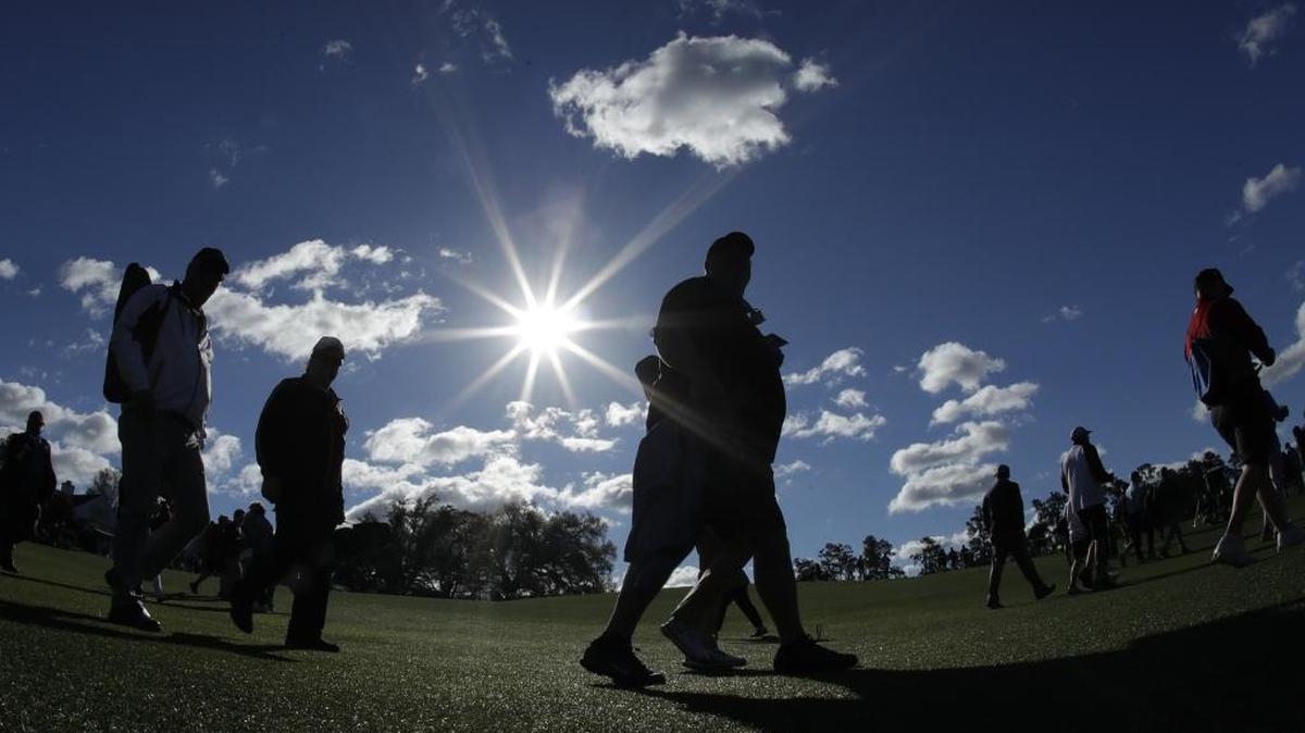Golf patrons walk along the first fairway during the first round for the Masters golf tournament Thursday, April 6, 2017, in Augusta, Ga.