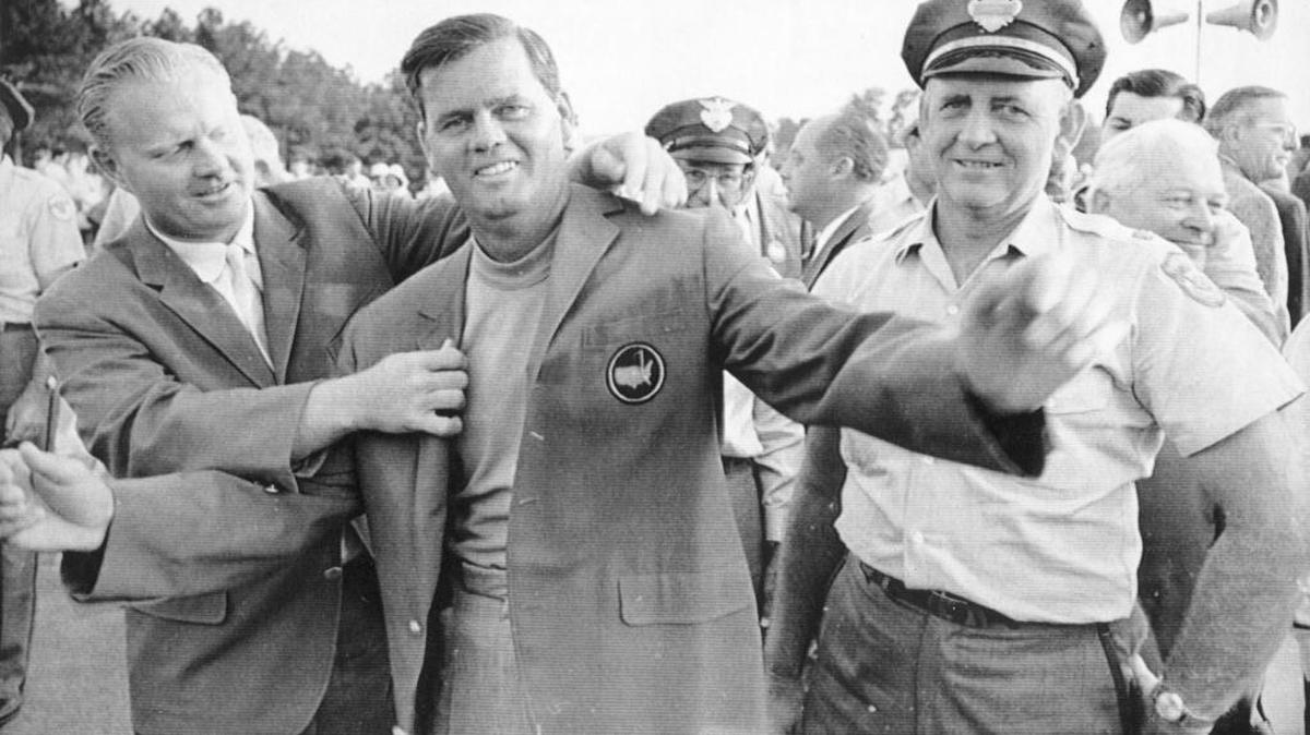 Gay Brewer Jr., center, gets a helping hand from Jack Nicklaus, left, as he tries on his traditional green blazer after winning the Masters on April 10, 1967. Nicklaus had defeated Brewer a year earlier in a playoff at the event.