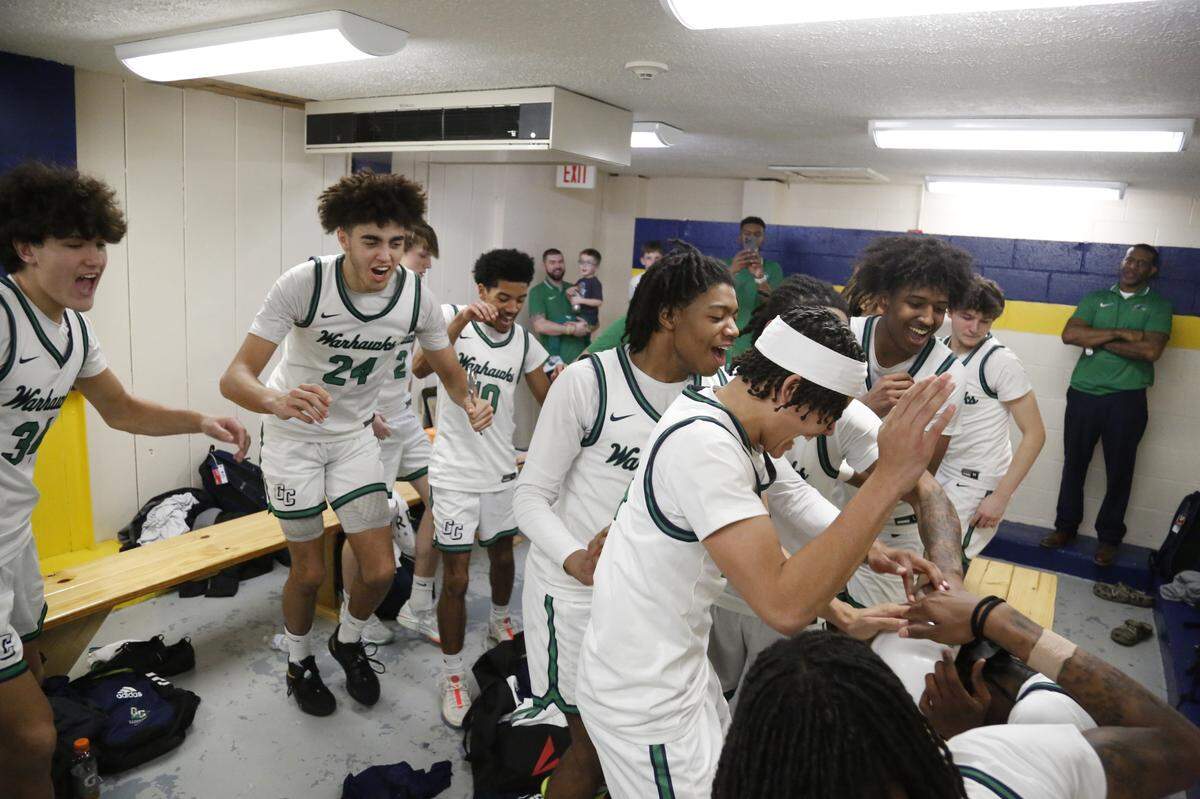 Great Crossing’s Malachi Moreno (24) and his Warhawks teammates swarm senior Jaylen Warren, seated right, in the locker room after their win over Lexington Catholic on Saturday at Franklin County High School in Frankfort. Warren earned the team’s “hard hat” award for his defensive effort in the game.