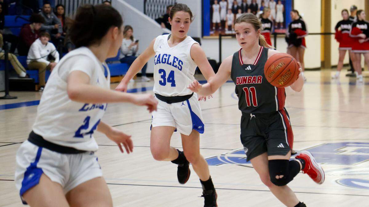 Paul Laurence Dunbar’s Layla Flynn (11) pushes the ball upcourt as Lexington Christian’s Claire Roberts (24) and Jentry Bertram (34) defend during their 43rd District Tournament opening-round game at Lexington Christian Academy on Monday.