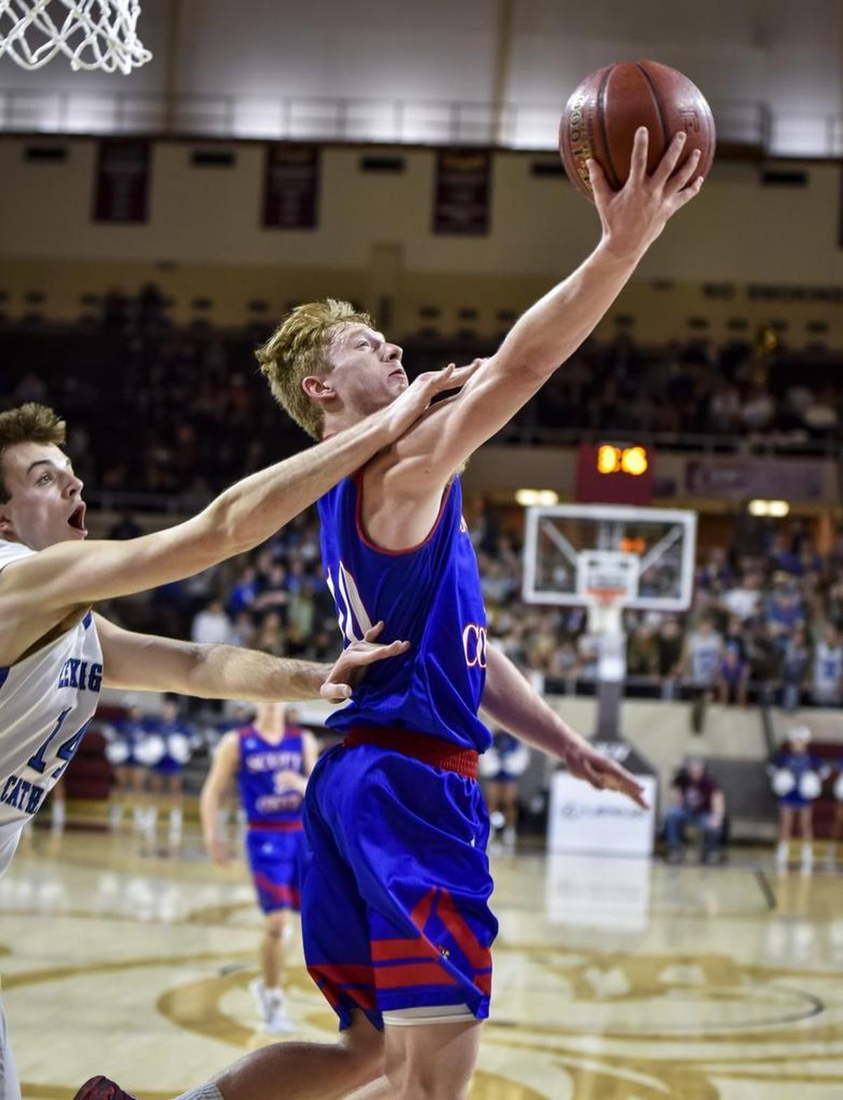 Scott County's Cooper Robb (10) shoots a reverse layup around Lexington Catholic's Max Sparkman (14), during the boys 11th Region Tournament finals, Monday, March 6, 2017, at EKU's McBrayer Arena in Richmond.