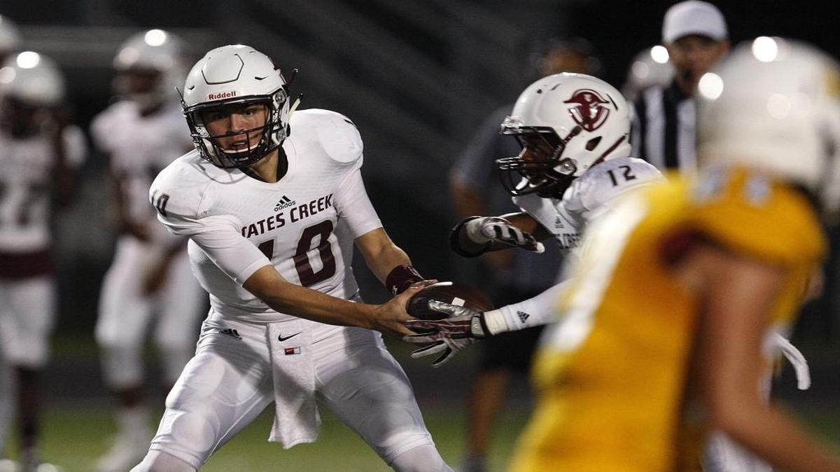 Tates Creek quarterback Cameron Workman handed off to Langston Love against Bryan Station on Sept. 23.