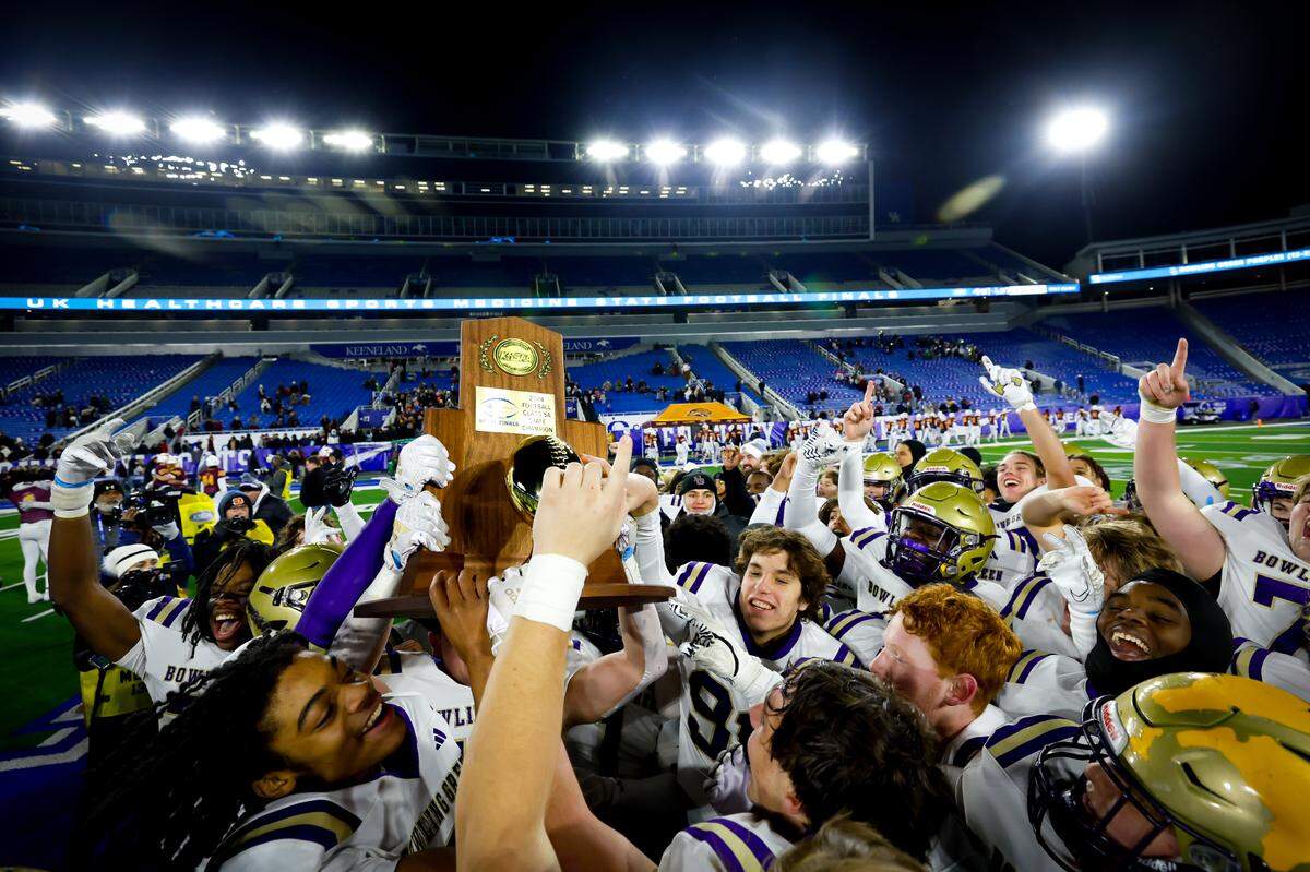 Bowling Green’s Deuce Bailey, left, raises the championship trophy with his teammates after the Purples’ 37-20 win over Cooper in the Class 5A state championship game.