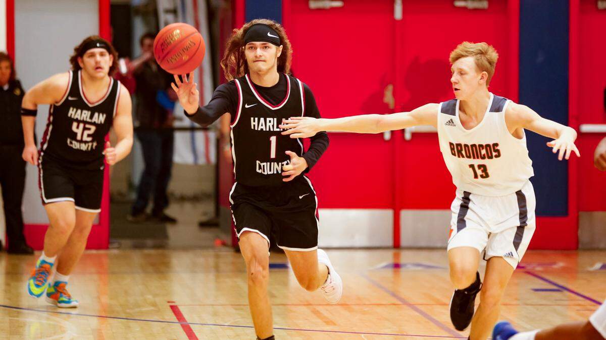 Harlan County’s Reggie Cottrell (1) passed the ball ahead during a fast-break opportunity as Frederick Douglass guard Tate Robinson gave chase during their Jock Sutherland Classic game at Lafayette High School on Saturday.