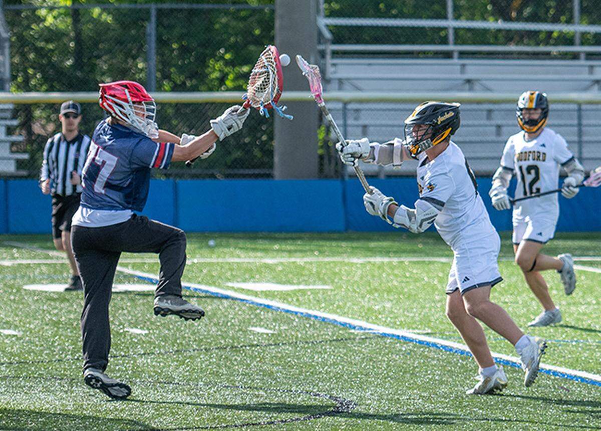 Lafayette’s Dylan Hunt, left, stops a shot by Woodford County’s Grey Hodge during the Yellow Jackets’ win in the 8th Region boys lacrosse semifinals at Lexington Catholic High School on Saturday.