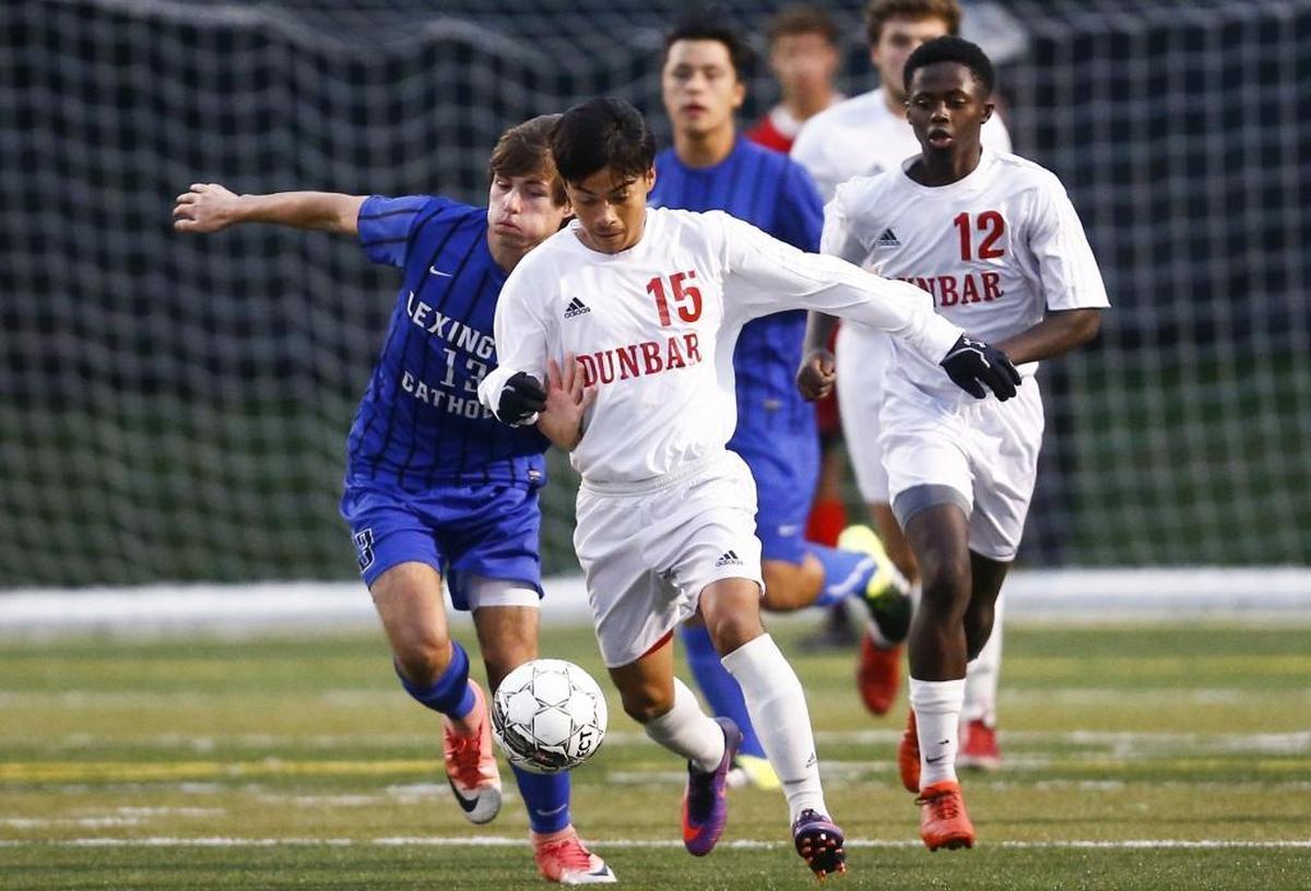 Lexington Catholic's Joseph Stuber (13) and Paul Laurence Dunbar's Crescenio Torres (15) battle for the ball during the 43rd District finals at Paul Laurence Dunbar High School in Lexington, Ky., Thursday, Oct. 12, 2017. Lexington Catholic beat Paul Laurence Dunbar 2-1 on penalty kicks.