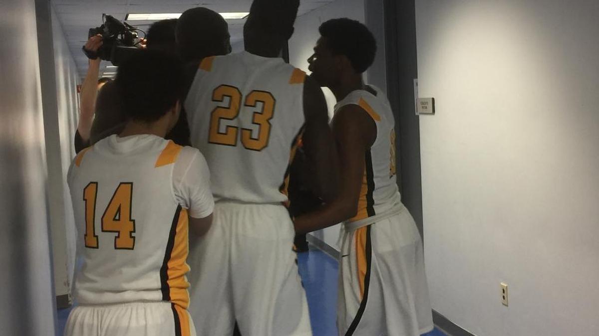 Cordia’s Kareem McDonald (14), Oumar Keita (23) and Anthony Nelson huddled around their coach, Rodrick Rhodes, after an emotional win over Newport Central Catholic in the semifinals of the boys’ All “A” Classic on Saturday, Jan. 30, 2016.