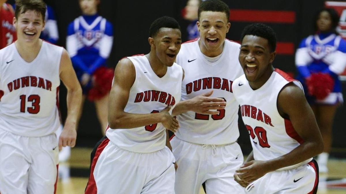 Paul Dunbar’s Justin Kelley (13), Jordan Lewis (0), Darius Williams (23) and Jordan Brown celebrated a run that forced a Lafayette timeout. Dunbar defeated Lafayette 73-42 on Jan. 26.
