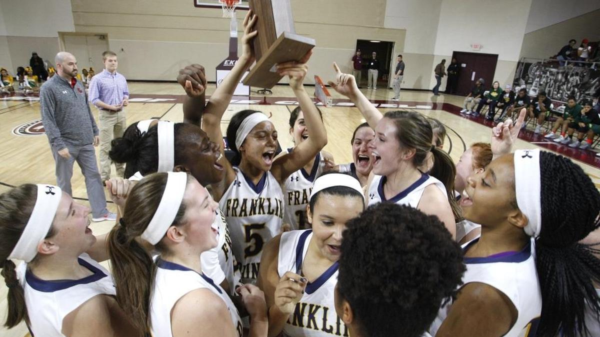 Franklin County's Princess Stewart, the tournament MVP, hoists the trophy with her Lady Flyers after defeating Bryan Station to win the girls 11th region basketball championship at Paul J. McBrayer Arena in Richmond, Ky., Saturday, March 5, 2016.