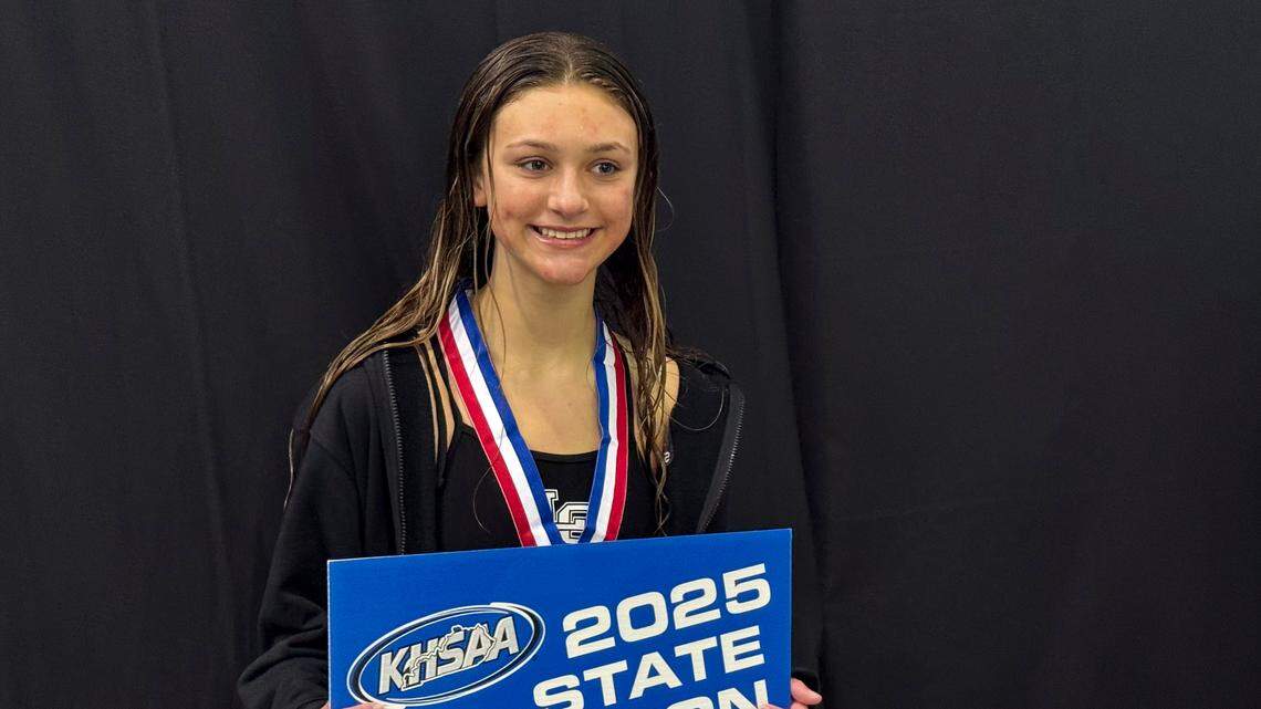 Lexington Catholic’s Sydney Leslie poses for the media after receiving her medal and placard for winning the KHSAA Girls State Diving Championships at the University of Kentucky’s Lancaster Aquatic Center on Friday.