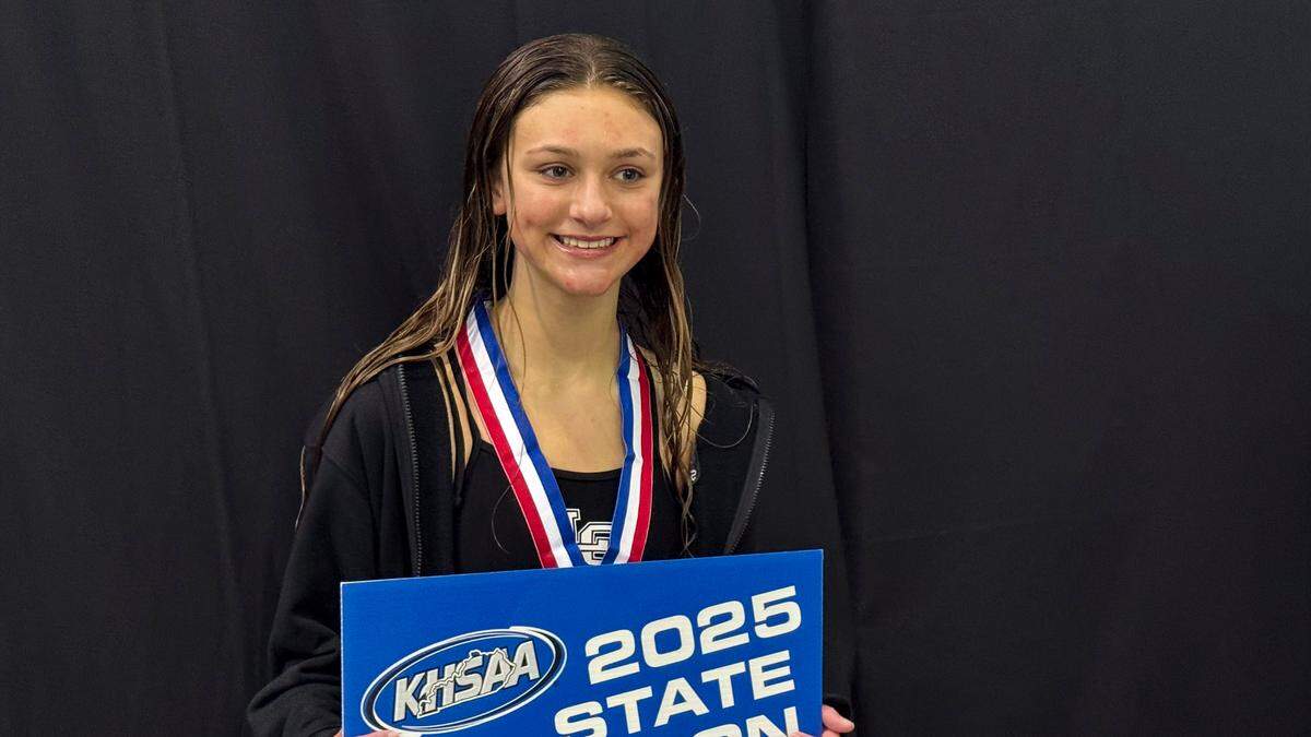 Lexington Catholic’s Sydney Leslie poses for the media after receiving her medal and placard for winning the KHSAA Girls State Diving Championships at the University of Kentucky’s Lancaster Aquatic Center on Friday.