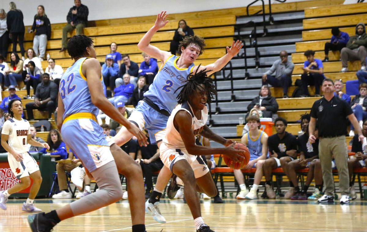 Frederick Douglass guard Aveion Chenault splits the defense of Henry Clay’s Cole Wicker (32) and Isaiah Stephan (2) during the Broncos’ 71-44 win over the Blue Devils at Frederick Douglass High School on Tuesday. Chenault led Douglass with 16 points.