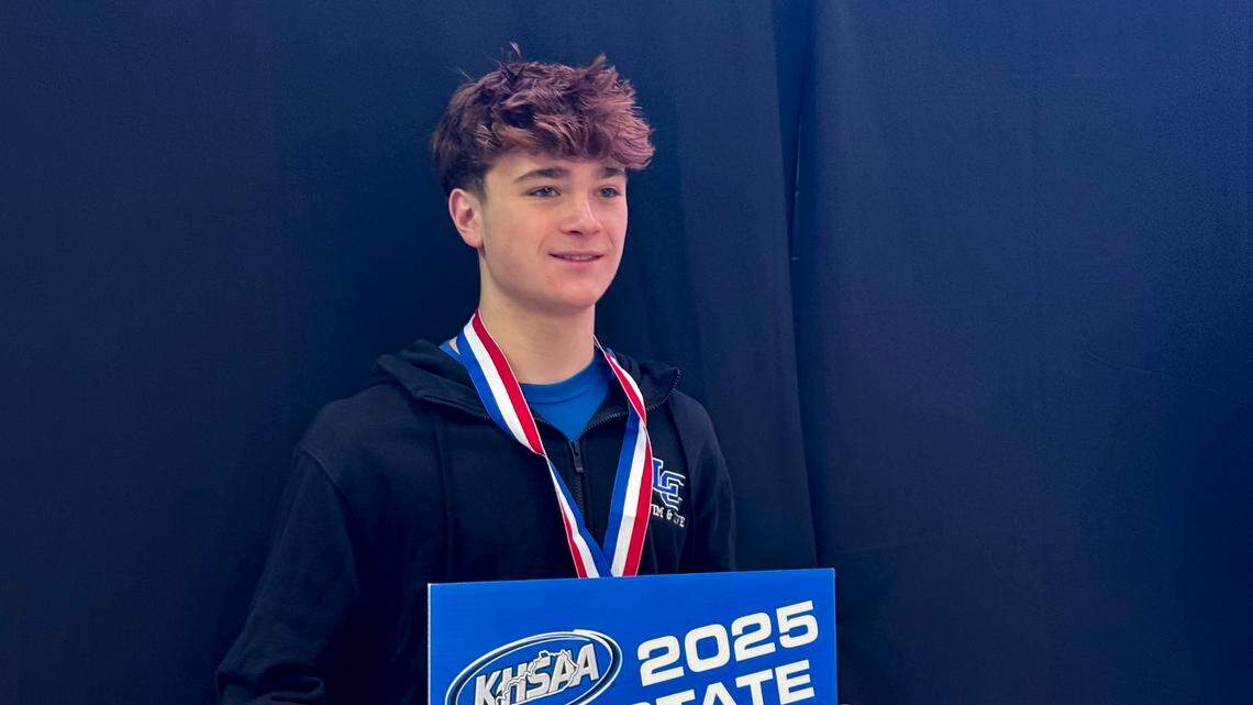 Lexington Catholic’s Graham Leslie poses for the media after receiving his medal and placard for winning the KHSAA Boys State Diving Championship at the University of Kentucky’s Lancaster Aquatic Center on Saturday.