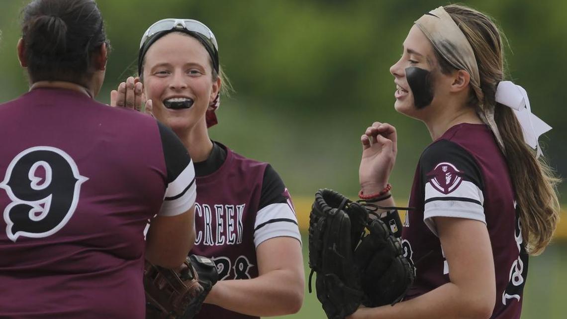 Tates Creek senior Breonna Williams (9), senior Kendall Fields (28), and junior Marina Dickinson (3) huddle and high-five after a play during the District softball semifinals tournament Tates Creek vs Paul Laurence Dunbar at Lexington Christian Academy on Tuesday, May 23, 2017. Tates Creek Lady Commodores lead in the fourth inning 6-2.