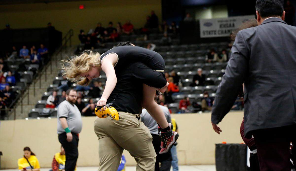 Boyle County’s Lyla Smith receives a celebratory escort off the mat by assistant coach Elliott Porter after her win in the 114 finals at the girls KHSAA Wrestling State Championships at the Kentucky Horse Park’s Alltech Arena on Saturday.