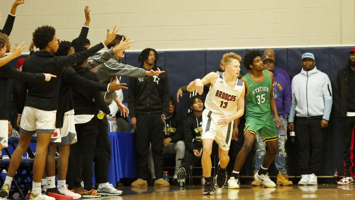 Frederick Douglass’ bench players cheered after Tate Robinson (13) knocked down a second-half 3-pointer over Bryan Station’s Taeshawn Adams (35) on Monday night.
