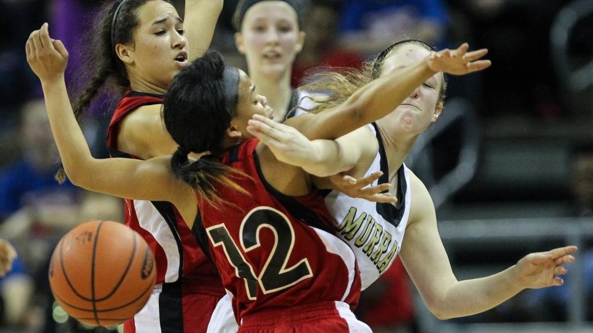 Murray's Brittany Lawson passes the ball around a Manual double team of Amara Ballard and Tyonne Howard, 12, during Murray's 58-41 win in the first round of the 2016 St. Elizabeth Healthcare/KHSAA Girls' Sweet 16 State Tournament, Thursday, March 10, 2016.
