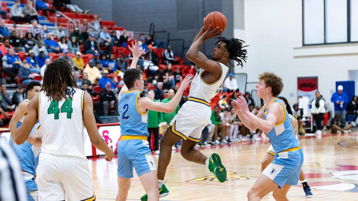 Bryan Station’s Amari Owens goes up for a shot between Henry Clay’s Kade Hilander (2) and Jackson Stephan, right, during the Defenders’ 60-48 win in the 42nd District Tournament semifinals at Scott County High School’s Billy Hicks Gymnasium in Georgetown on Wednesday.