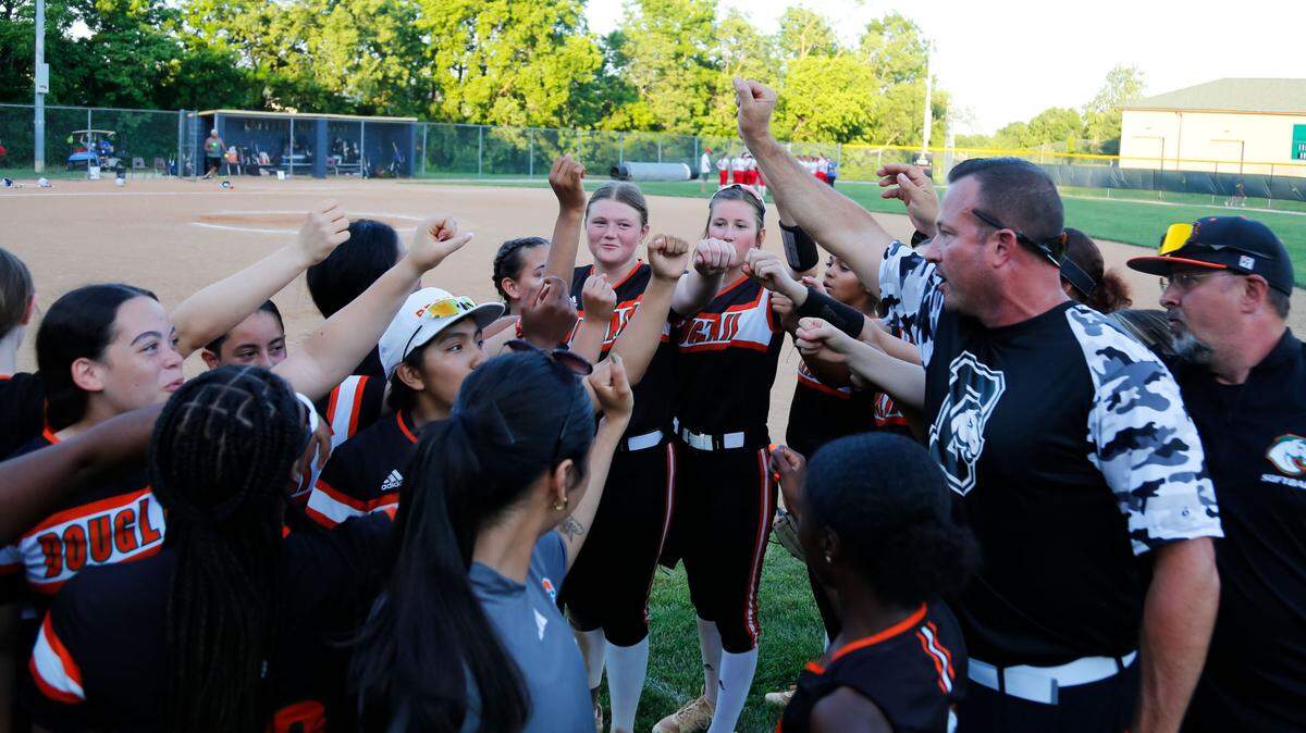 Frederick Douglass, led by head coach Jason McGuire, second from right, celebrated defeating Scott County 11-1 in the 42nd District softball tournament semifinals at Bryan Station High School on Tuesday.