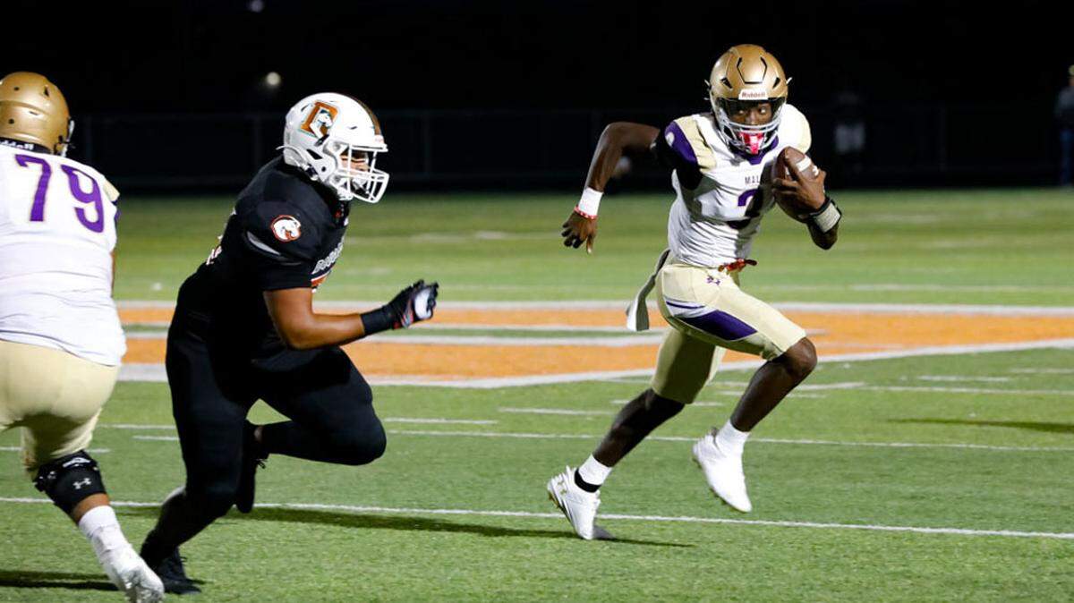 Male’s Antonio Harris (3) tries to elude Frederick Douglass’ Seandre Maxberry during the Bulldogs’ 31-28 win over the Broncos at The Farm on Friday.